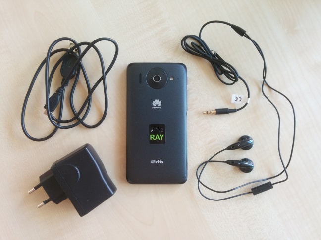 De achterzijde van de RAY-telefoon met bijgeleverde micro-usb-kabel, usb-lader en headset