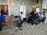 group of people working on computers at different tables
