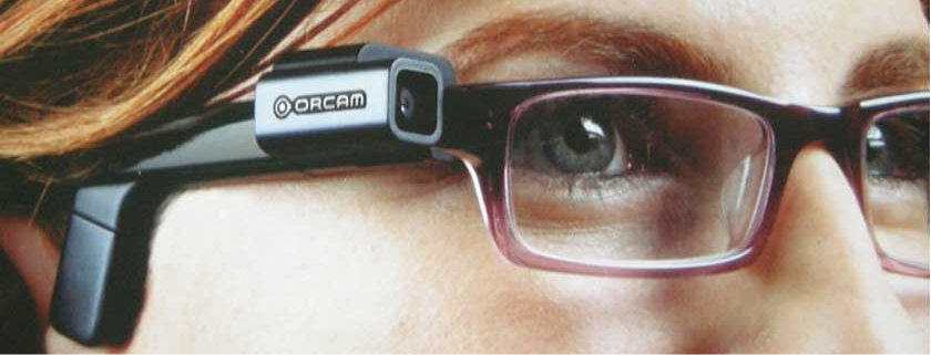 close-up foto van rechtervrouwenoog met bril waarop de OrCam vastgeklikt zit