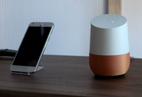 Smartphone en Google Home aast elkaar op tafel