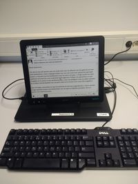 zwart-wit e-ink scherm waarop tekst te lezen is, aangesloten op een laptop