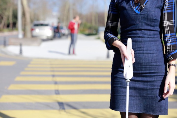  foto van gebruiker met de WeWalk witte stok met obstakeldetector