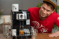 Een koffiezetapparaat met een lachende Arne Preuss op de achtergrond.