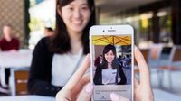 Smartphone met beeld van vrouw die voor de camera staat; daaronder een beschrijving van het beeld.