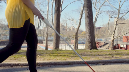 Vrouw die in een parkomgeving een traject loopt met de WeWalk Smart Cane